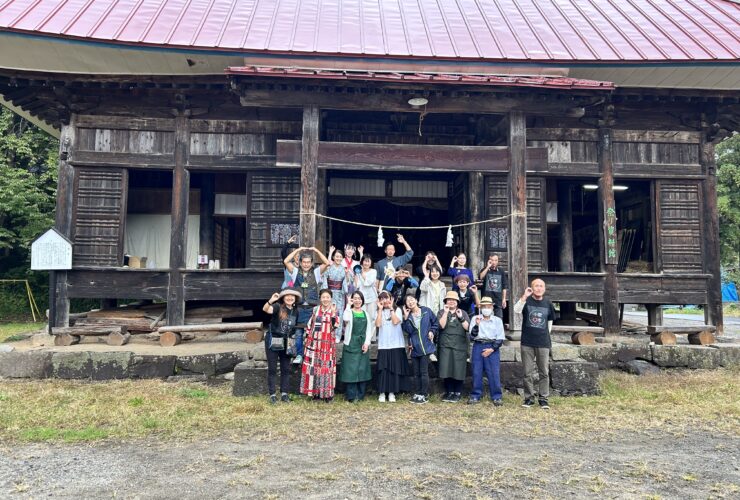 歴史ある木造建築の前で記念撮影をする参加者たち