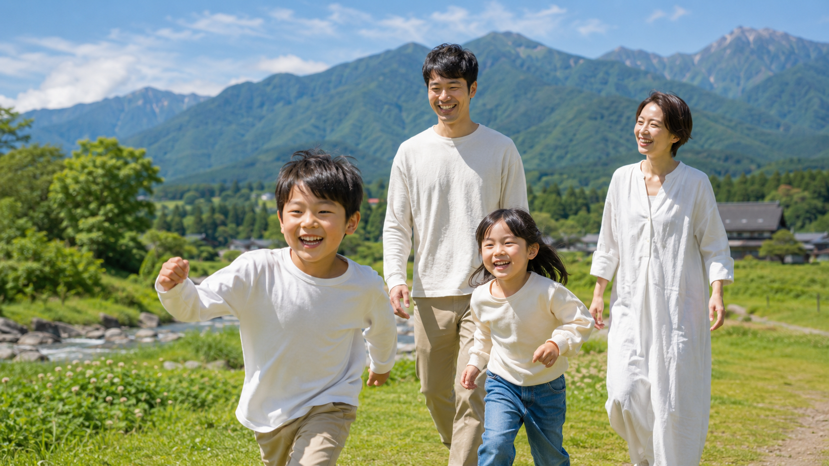 Family strolling along a riverside path with lush green mountains in Iiyama, Nagano