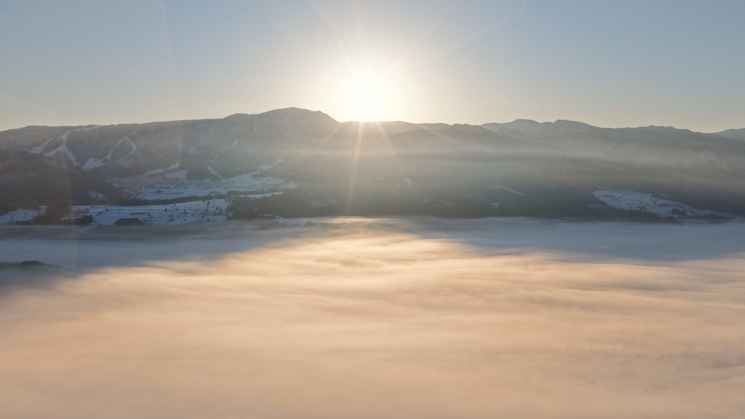 飯山市の山並みから昇る朝日と雲海の風景