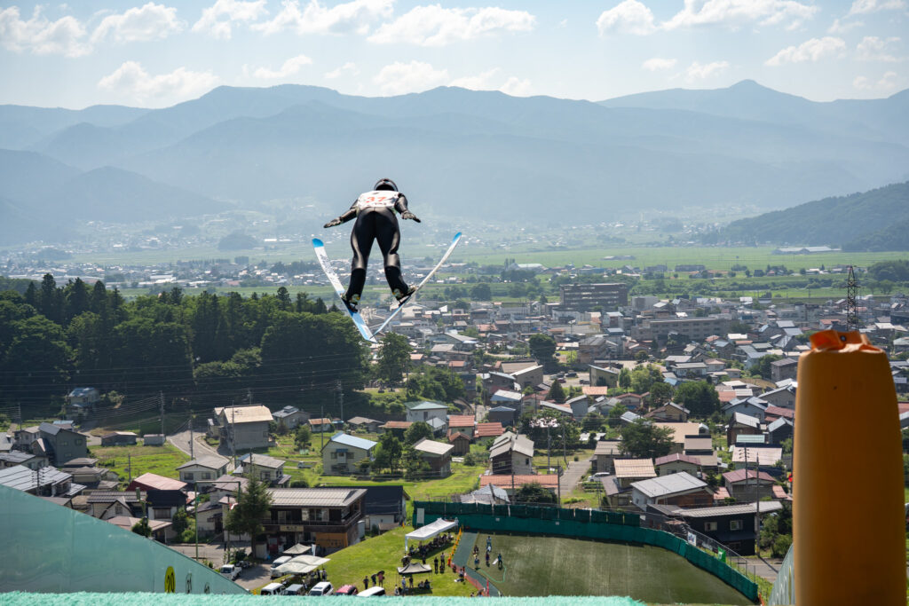 町並みを見下ろしながら飛行するスキージャンパー