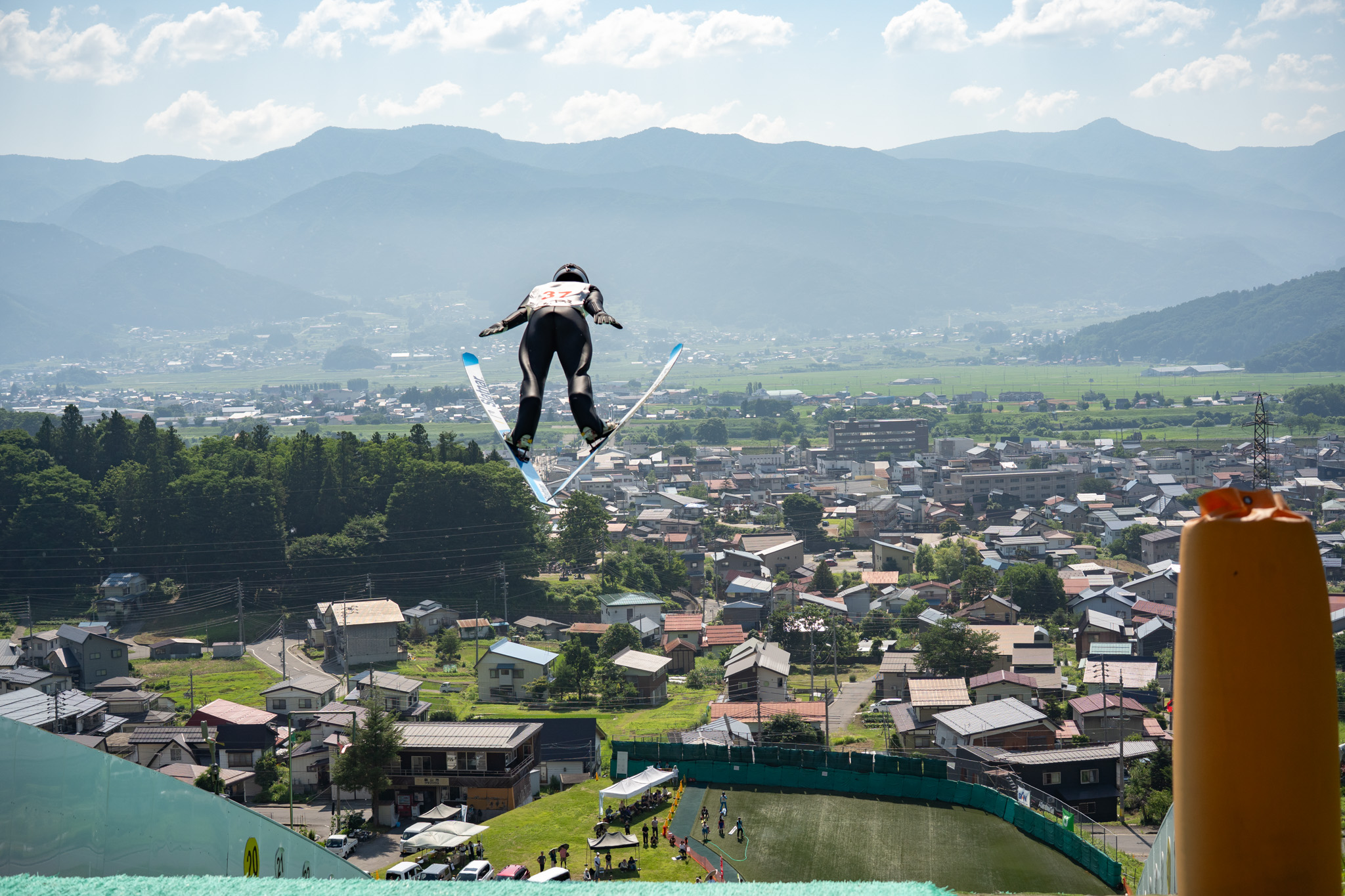 町並みを見下ろしながら飛行するスキージャンパー