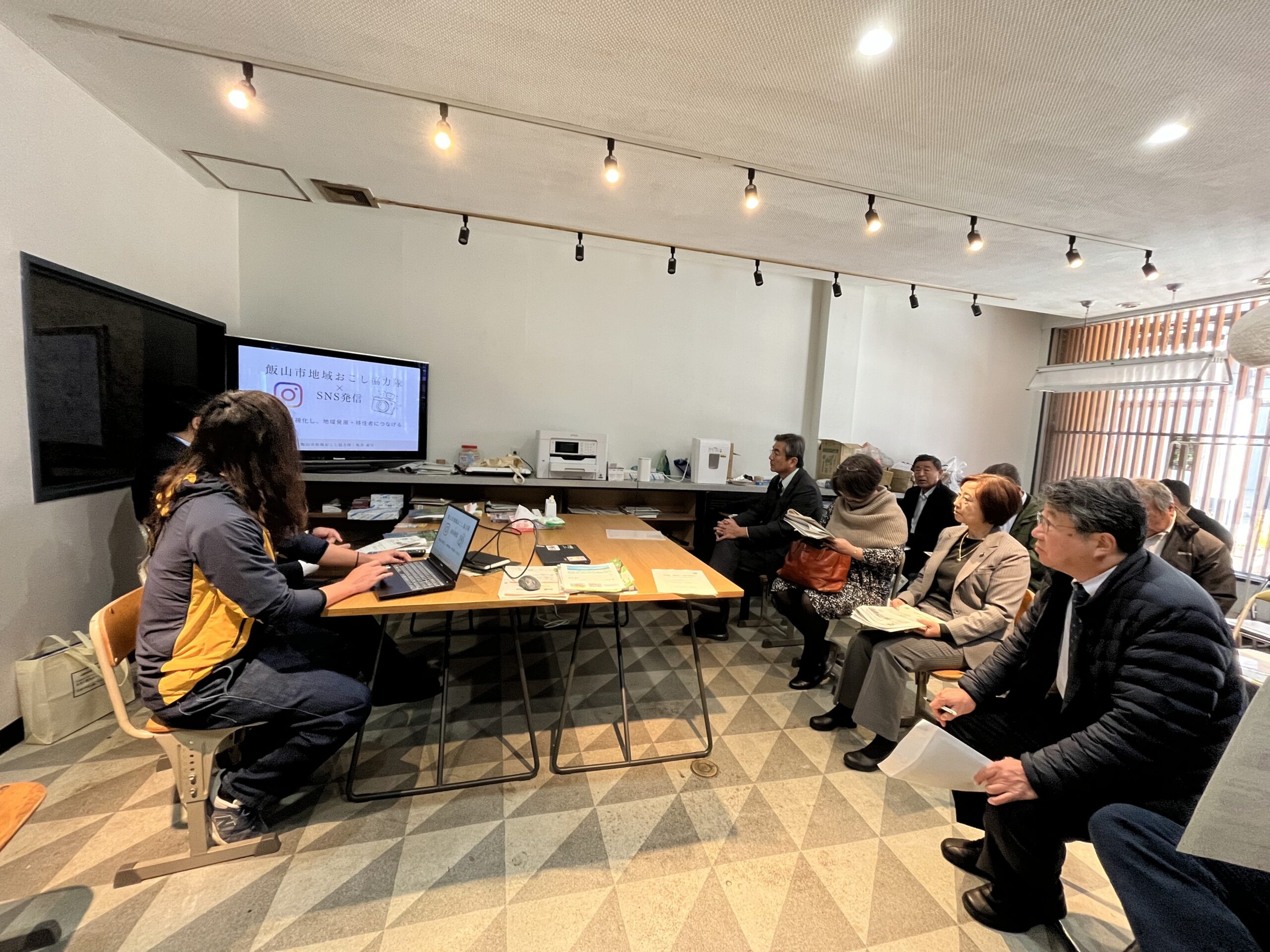 飯山市地域おこし協力隊によるSNS活用講座の様子。参加者が資料を手に説明を聞いている室内セミナー風景